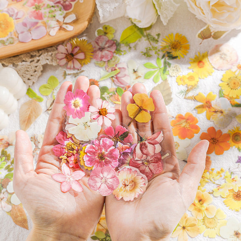 Hands holding a heap of pink, yellow and orange flower stickers above a spec list of 45 pieces and 38 mm size