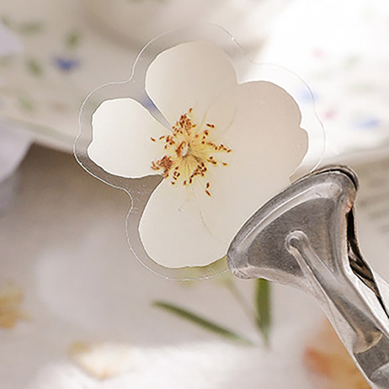 Autumn flower stickers on a burnt-edge letter, and a clear white flower sticker held in a metal clip