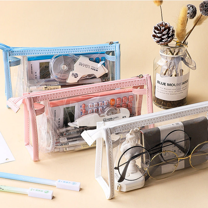 Blue, pink, and white clear triangular zipper pencil cases filled with calculators and stationery