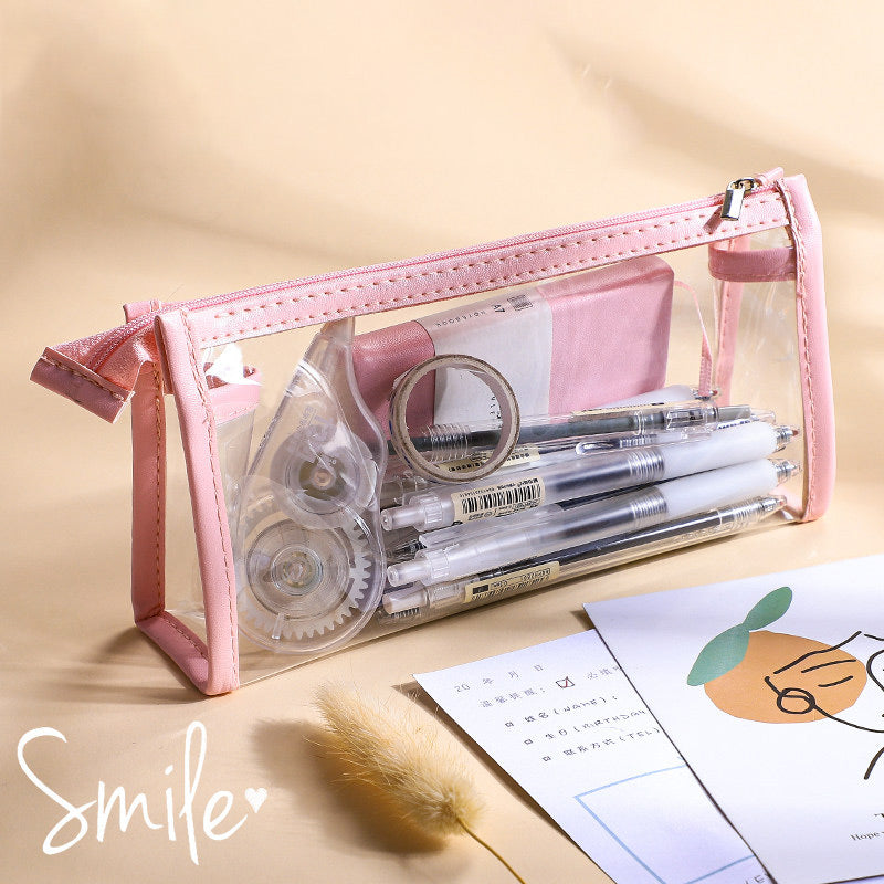 Clear triangular zipper pencil case with pink trim, filled with pens and stationery