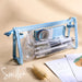 Clear triangular zipper pencil case with blue trim, filled with pens and stationery