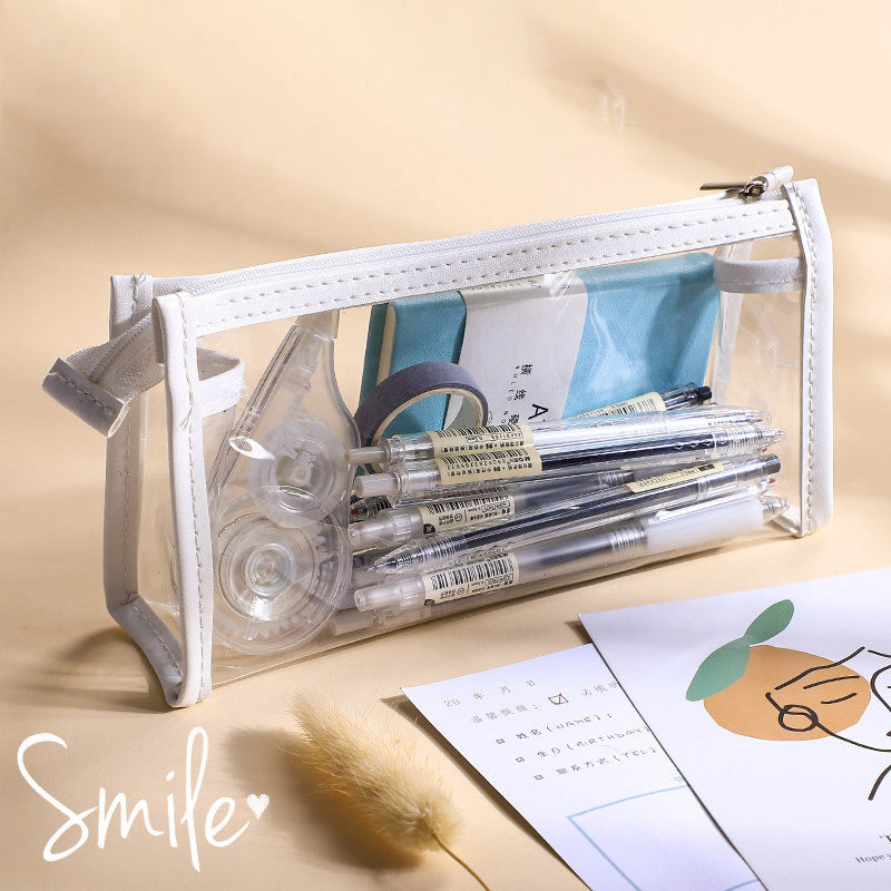 Clear triangular zipper pencil case with white trim, filled with pens and stationery