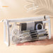 Hand holding a clear triangular zipper pencil case with white trim packed with stationery