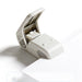 Open pale white stapleless stapler with the lever raised, standing on the edge of a sheet of white paper