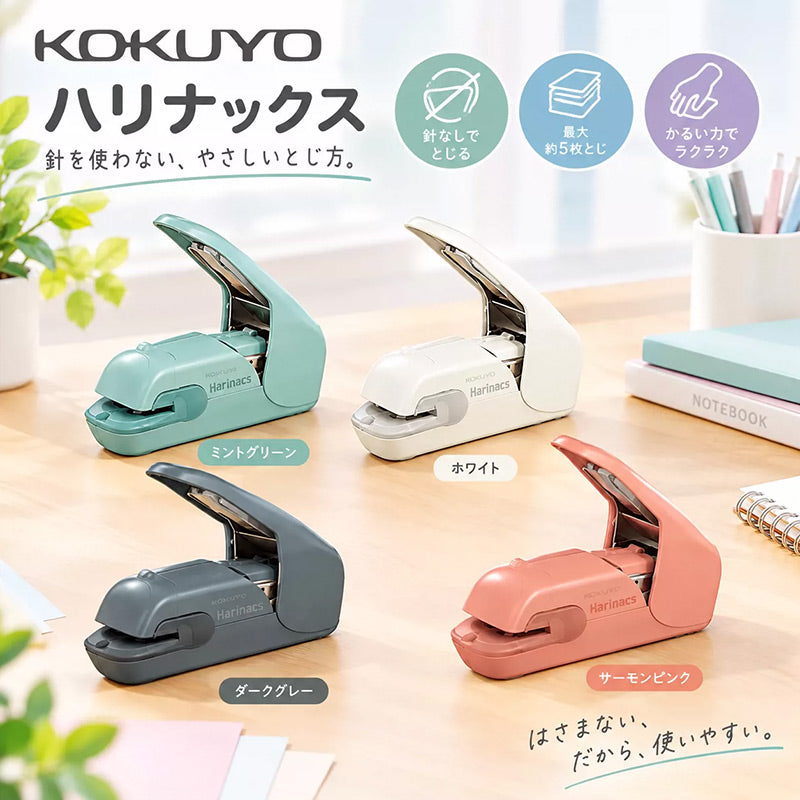 Four Harinacs stapleless staplers in teal, white, dark grey and salmon pink on a wooden desk beside notebooks