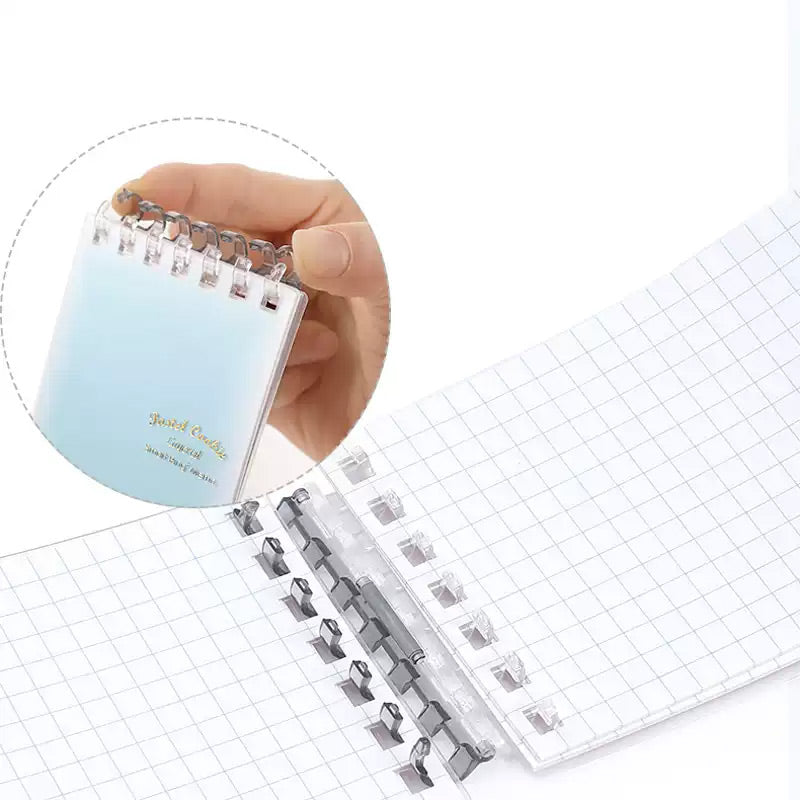 Hand pressing ring binder tabs to open and close the memo spine