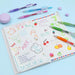 Bundle of gel pens surrounded by small flower stickers on a desk