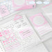 Pink index card box, schedule cards and a triangle marker on a notebook with pink stickers beside a keyboard