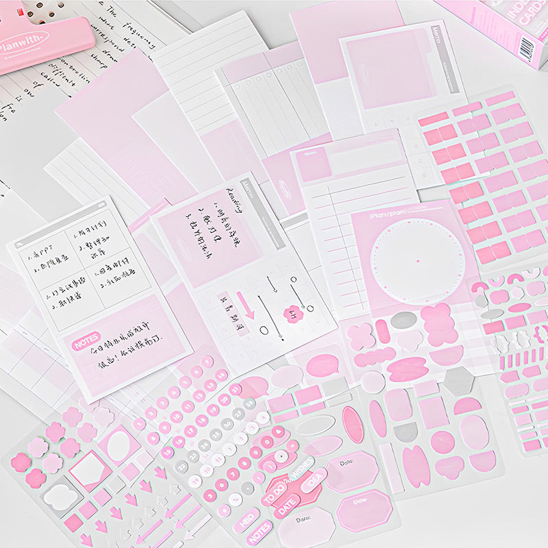 Pink index cards and sticker sheets laid flat, showing lined, grid, calendar and schedule layouts