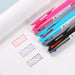 Pink, sky blue, black and white multi pens beside red, blue and black hatched ink swatches on a sheet of paper